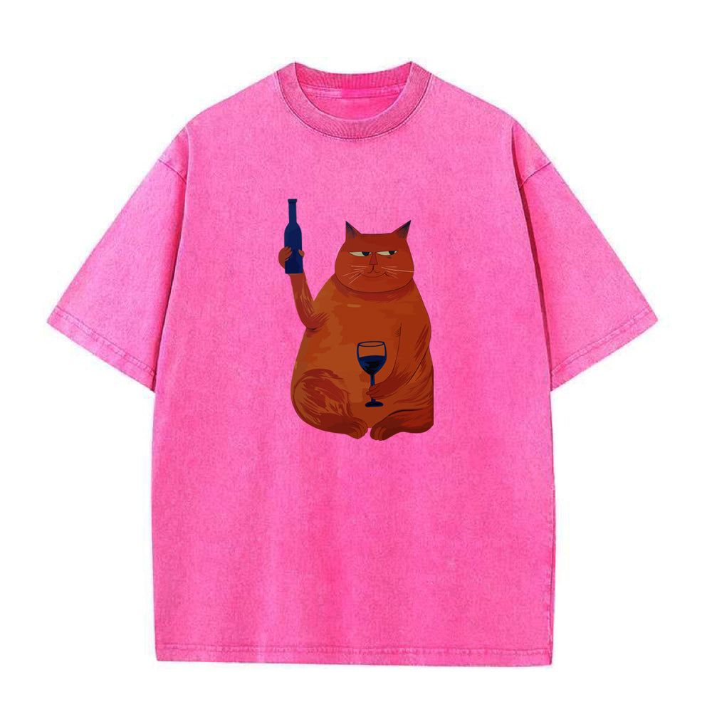 Pink t-shirt with a graphic of a cat holding a bottle and glass on a white background