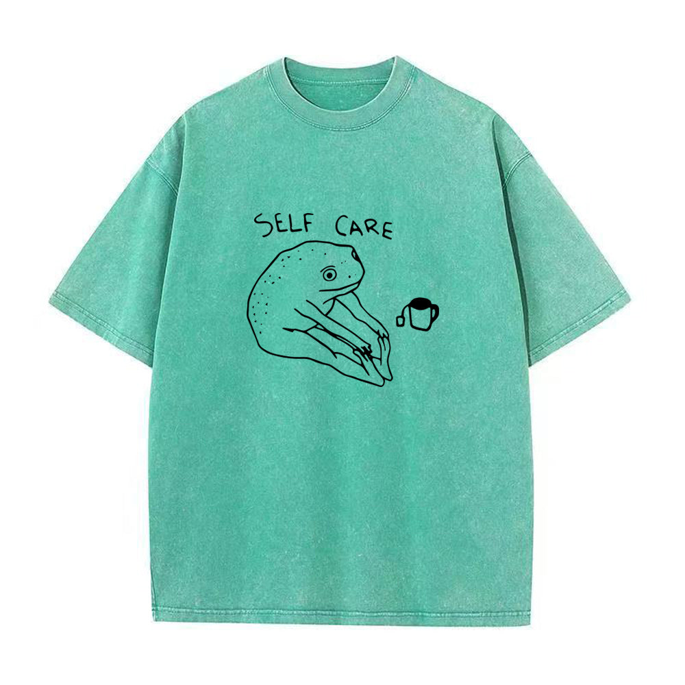 Green t-shirt with 'Self Care' and hand holding a cup illustration on a white background