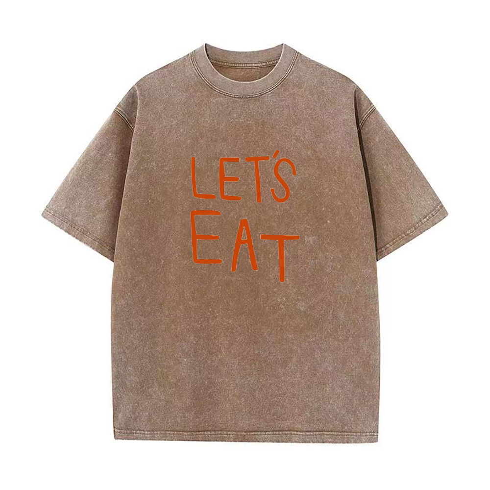 Oversized brown crew neck t-shirt with the text 'LET'S EAT' written in orange on the front.